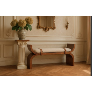 Vista frontale della panca curva Stirrup con struttura Amber Oak, seduta in bouclé e fasce a staffa.