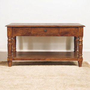 Vista frontale del tavolino in mango con gambe tornite, cassetti e ripiano inferiore.