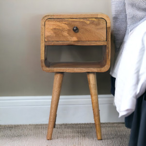 Comodino compatto in legno massello di mango effetto rovere, con un cassetto, vano inferiore aperto e quattro gambe nordiche.